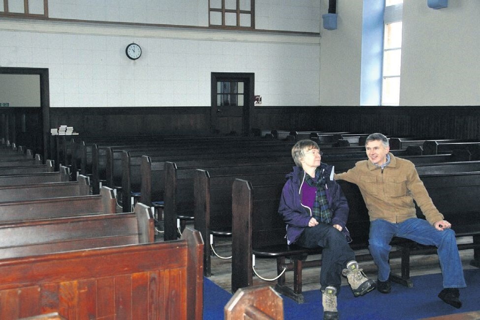 2014: Elder Calum Ferguson and wife Liz with the Campbeltown Free Church pews which are up for sale.