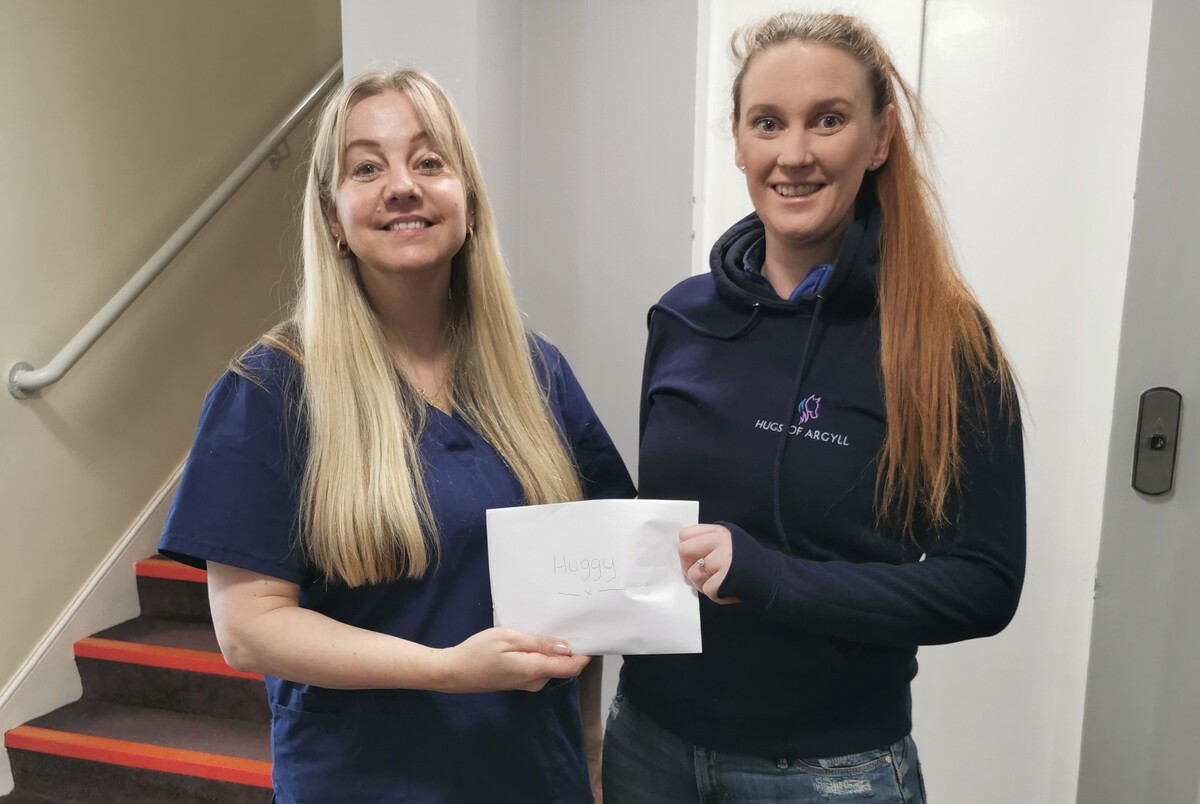 Kintyre Care Centre manager Jennifer McKellar, left, handing the money raised to Huggy’s emotional owner Caeleigh Kean.