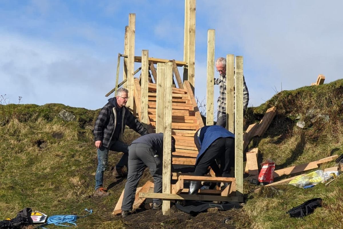 Some of the work party get to work on the back flight of steps. Photograph: Tarbert Castle Trust