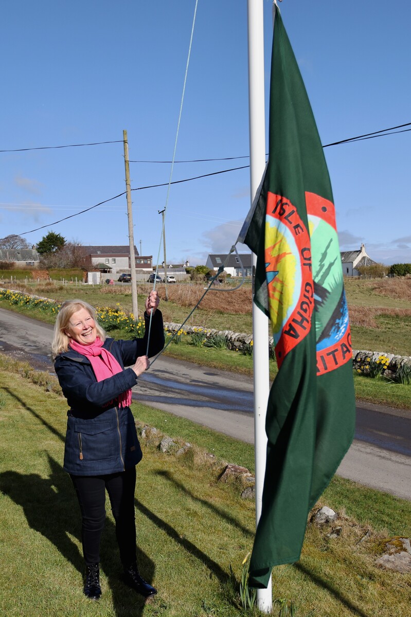 Anne Fraser, wife of Simon Fraser, given the honour of hoisting the Gigha Flag at the ceremony on the island Friday. Photograph: Kevin McGlynn.