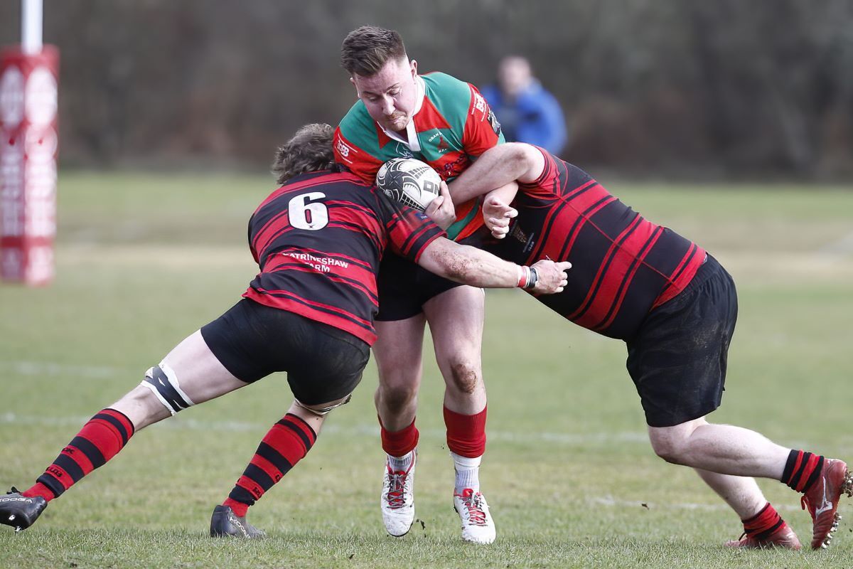 James Divers is squeezed out by two opposing players. Photograph: Stephen Lawson.