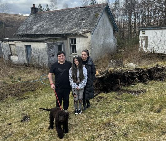 Charlie Duthie with his wife Nicola and their daughter Isla in front of Bridge of Orchy's old school ready for transformation to a family hospitality business. 