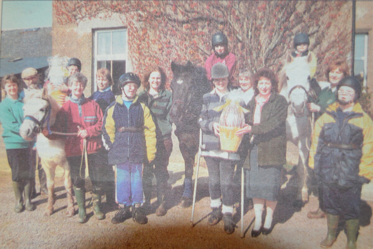 1999: Elizabeth MacDougall receiving her chocolate egg for South Kintyre Riding For The Disabled from Woolworths entertainment manager Lorna Mitchell as the other helpers and members look on.