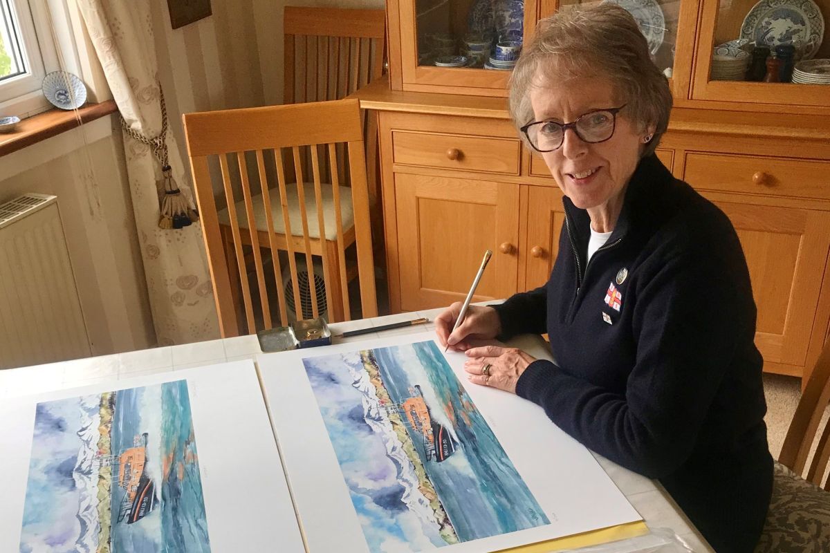 Artist and Oban RNLI fundraising volunteer Fiona Campbell with copies of her MayDay painting. Photograph: RNLI