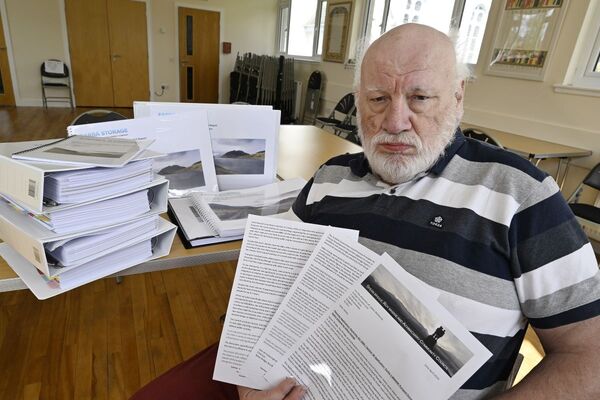 John Fotheringham with the wall of paperwork supplied for the public to browse through and the three page response from Community Councillors. Photograph: Iain Ferguson, alba.photos.