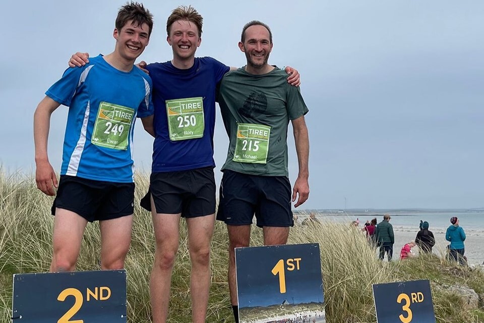 Rory Dowd (centre) celebrates his Tiree Half Marathon win with brother Ewan (left) and Michael Bossard.