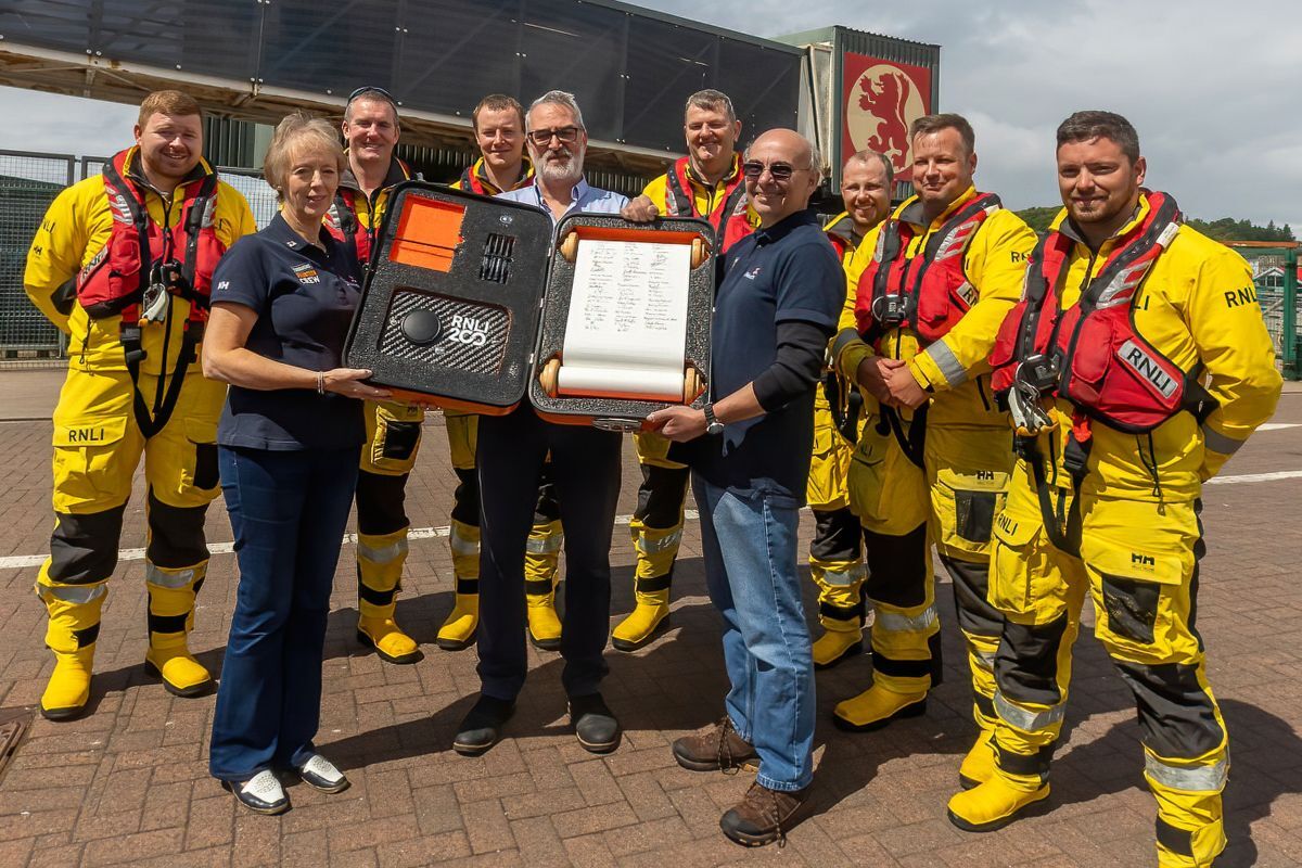 Holding the scroll and flanked by members of the crew are Oban’s signatories, left to right, Fundraising Coordinator Fiona Campbell, Ian Henry who is Chairman of Oban’s Lifeboat Management Group and Iain Paul who is manager of the lifeboat shop in the CalMac terminal. Holding the scroll and flanked by members of the crew are Oban’s signatories, left to right, Fundraising Coordinator Fiona Campbell, Ian Henry who is Chairman of Oban’s Lifeboat Management Group and Iain Paul who is manager of the lifeboat shop in the CalMac terminal.
