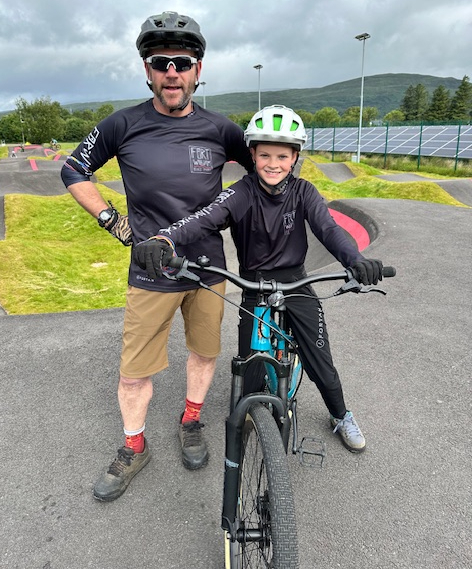 Gregor Muir, Chairman of the Fort William Bike Park, and Charlie show off their new bike tops.