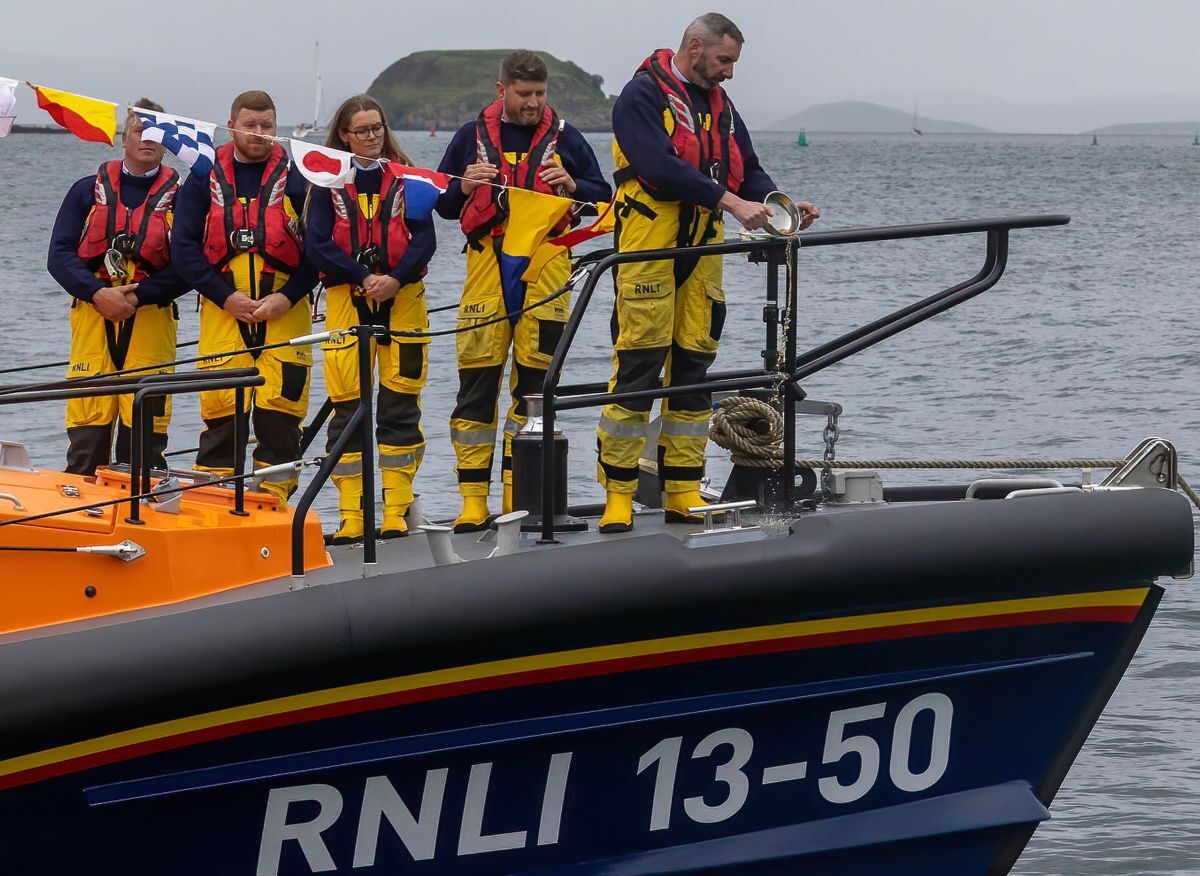 A crew member pours a quaich of Oban whisky on the bow to mark the naming of The Campbell-Watson. Photograph: Stephen Lawson/RNLI