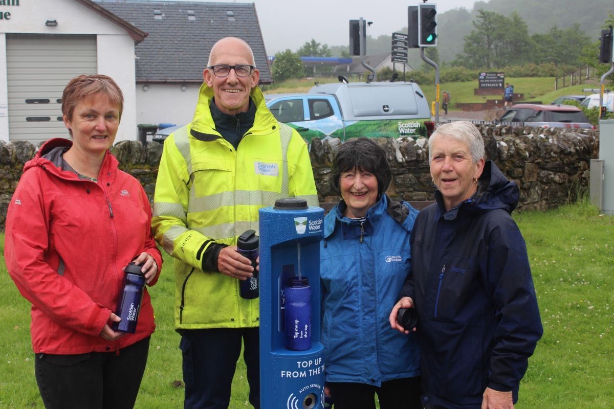 Helen Fairlie, Sally Mortimer and Gwen McTaggart from Glencoe and Glen Etive Community Council with Robert MacLean of Scottish Water at Glencoe’s new Top up Tap by the A82, in front of the village’s Mountain Rescue Team base.