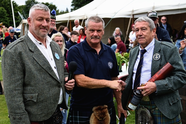 Games Convener Stephen King, left and Iain Lindsay, Inveraray games committee, make a presentation to Jim MacMillan retiring as treasurer after 34 years. Photograph: Kevin McGlynn