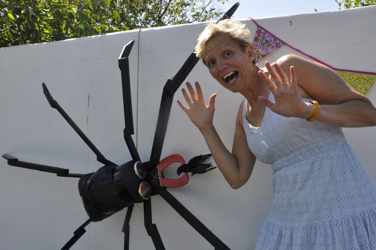 Annie Lawson gets fun spooked by a larger than life 'scary'crow spider in Ellenabeich oin Seil.