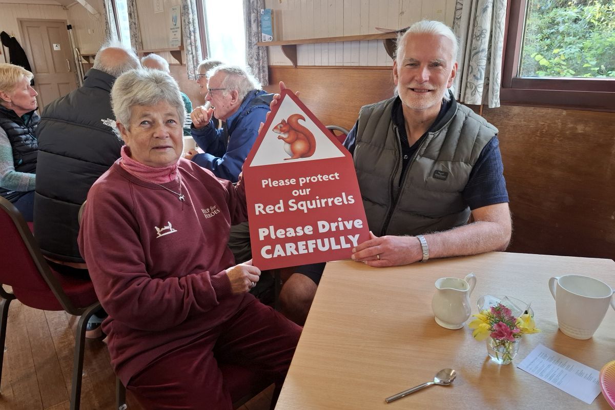 Carol Russell and Christopher Perkins with one of the signs.