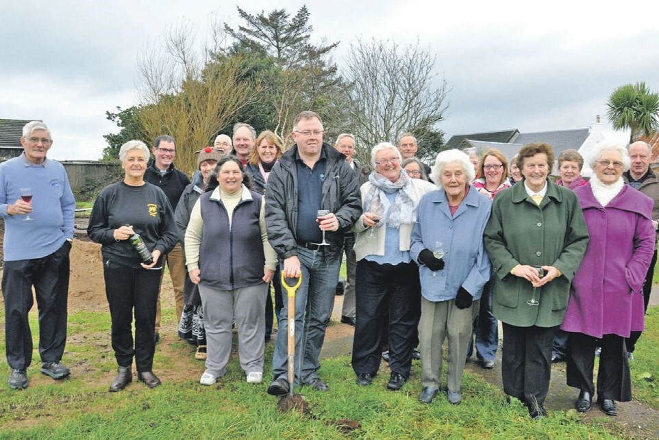 2014: David McCallum, centre, a member of the Dunaverty Hall Committee for 26 years, is surrounded by villagers as he cuts the first sod to officially mark the start development work on a new hall.