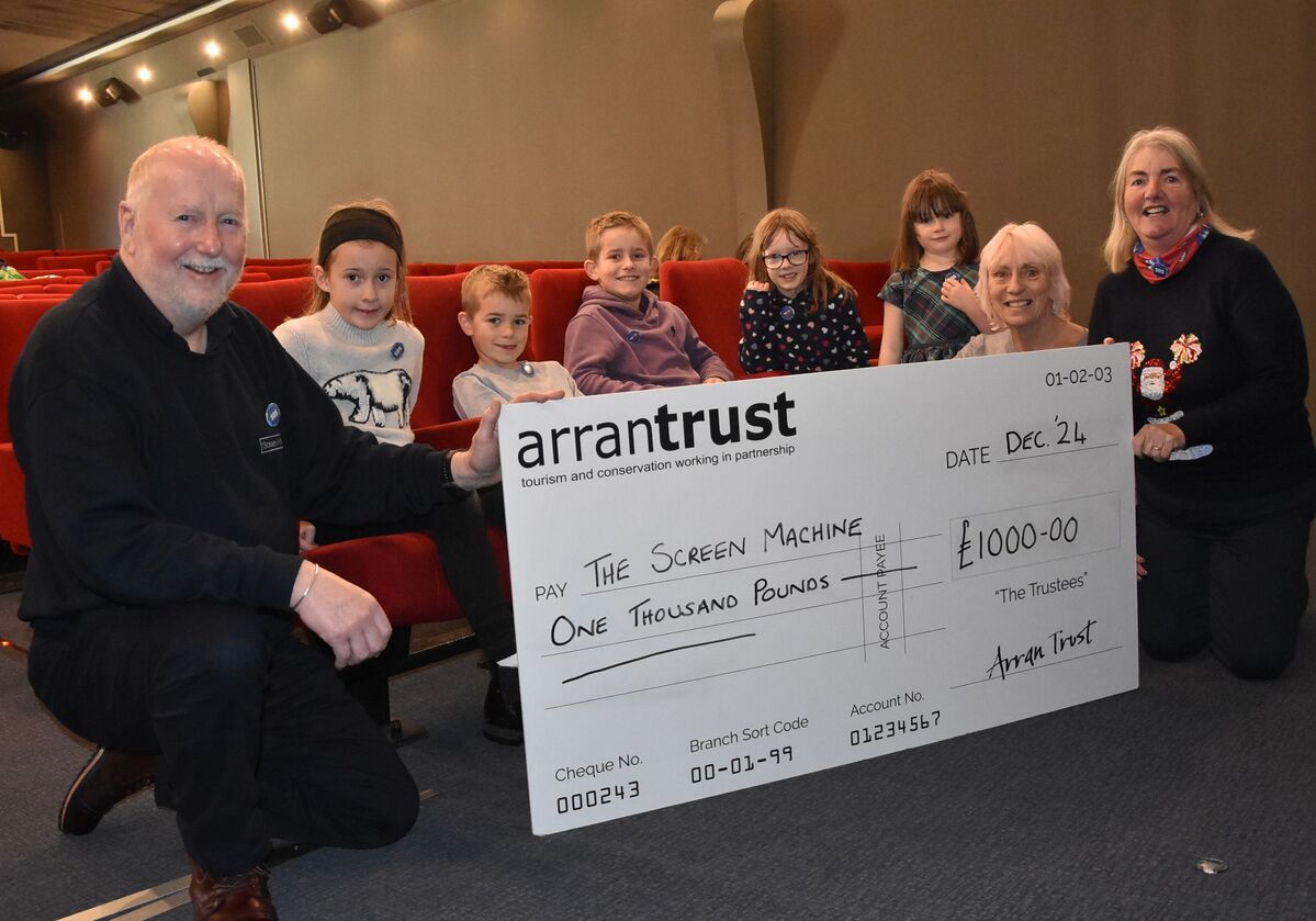 Screen Machine’s operator, Iain MacColl with young supporters Katie, Max, Joey, Betty and Daisy, with Arran Trust’s Sheila Gilmore and Screen Machine usher, Isobel MacDonald.