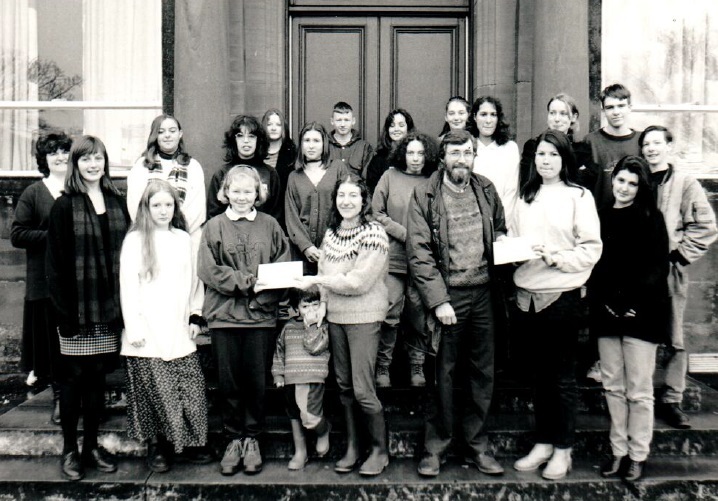 Arran High School’s community involvement class presents two £30 cheques to Mark Sheridan of Montrose House and Mandy McLean of Lamlash Playgroup.