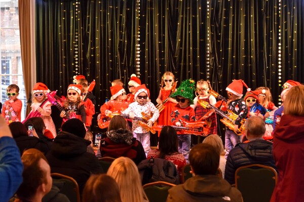 Nursery children rock around the Christmas tree