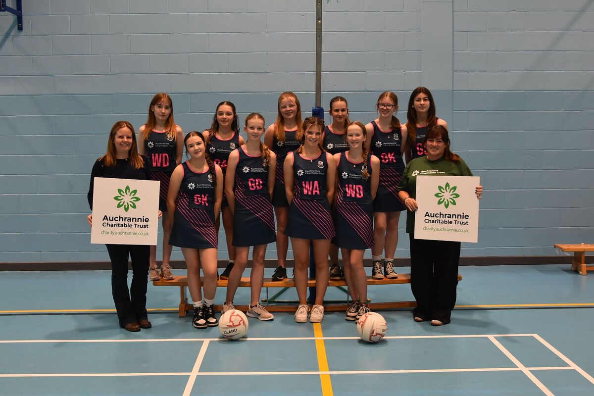 Team coach Michelle Williamson, left, and Auchrannie Charitable Trust’s Ashley Wright with the Arran High School netball team in their new kits. 