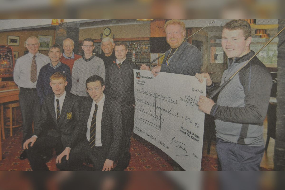 2015: Robert Macintyre receives the cheque on behalf of Glencruitten Golf Club from Rotary Club of Oban president Ronnie Neil, as Rotary members and golf club members look on. 