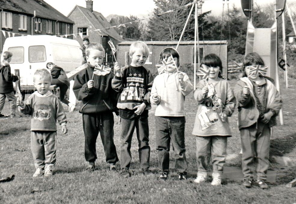 Children join in with Shiskine’s VE Day celebrations by waving their Union flags. Children join in with Shiskine’s VE Day celebrations by waving their Union flags.