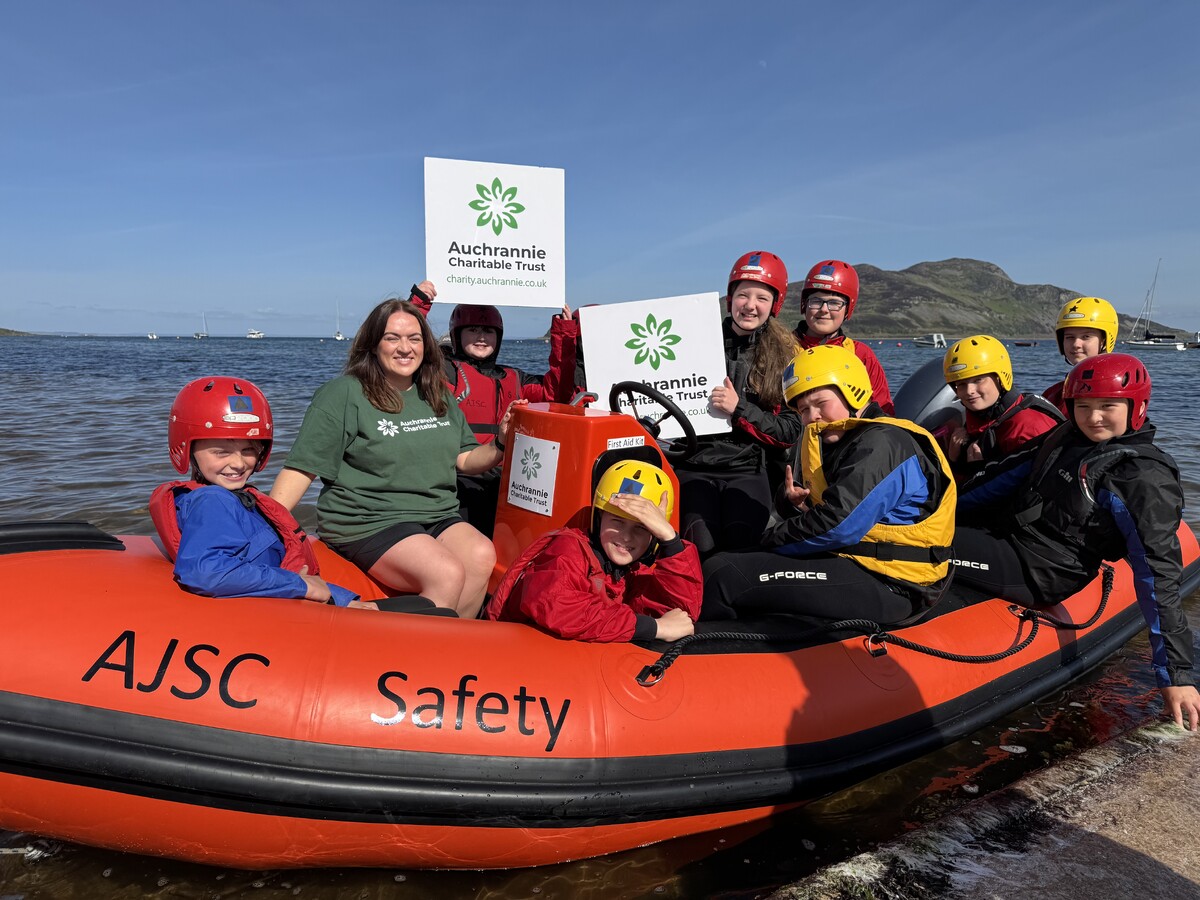 Ashley Wright from Auchrannie Charitable Trust (ACT) joins with AJSC members on the new safety boat which was made possible thanks to a significant donation from the trust and other organisations. Photograph: ACT. Ashley Wright from Auchrannie Charitable Trust (ACT) joins with AJSC members on the new safety boat which was made possible thanks to a significant donation from the trust and other organisations. Photograph: ACT.