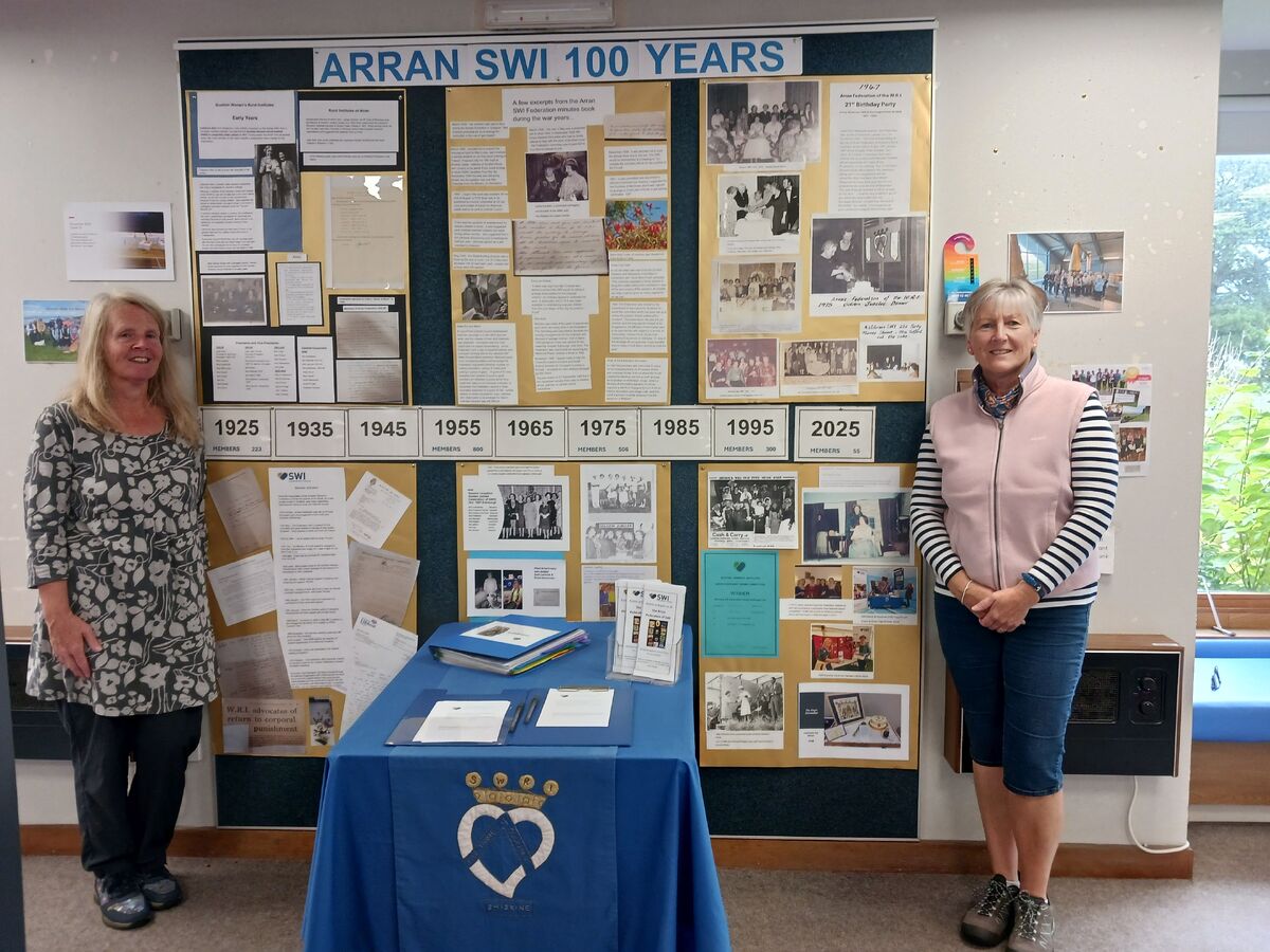 Evelyn Hamilton, secretary of the Arran Federation of SWI, and Susanna Talbot unveil the centenary exhibition at the library. Photograph: Susanna Talbot.