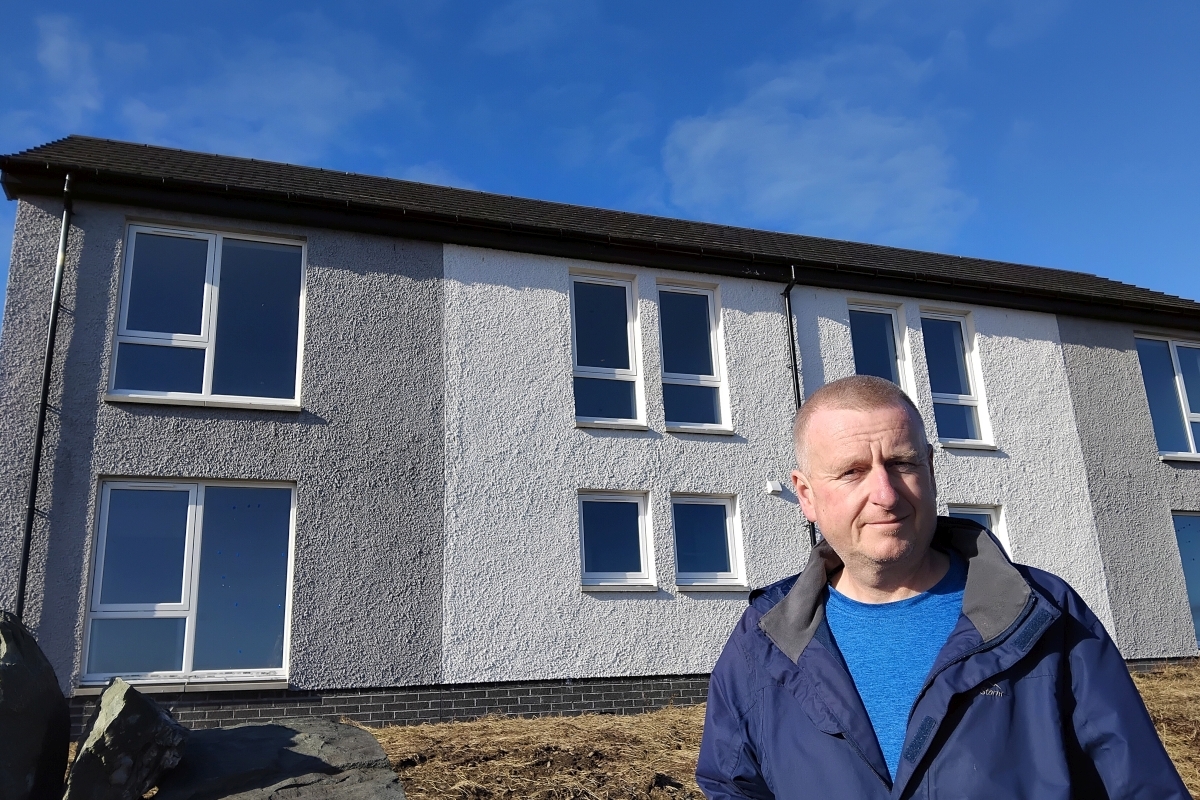 Councillor Dougie McFadzean outside the nearly complete housing at Port Charlotte. Photograph: Dougie McFadzean Councillor Dougie McFadzean outside the nearly complete housing at Port Charlotte. Photograph: Dougie McFadzean