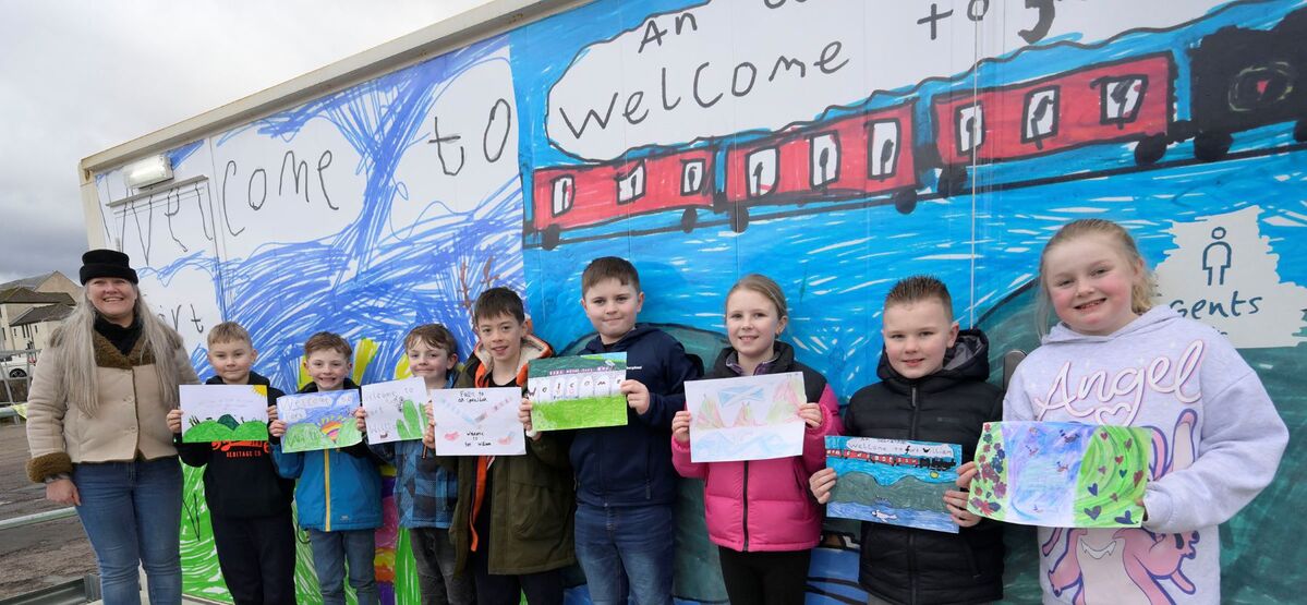 Sarah Kennedy, Fort William Marina and Shoreline Community Interest Company board member, left, stands alongside children of Caol Primary School with their original paintings which decorate the new building. Photograph: Iain Ferguson, alba.photos.