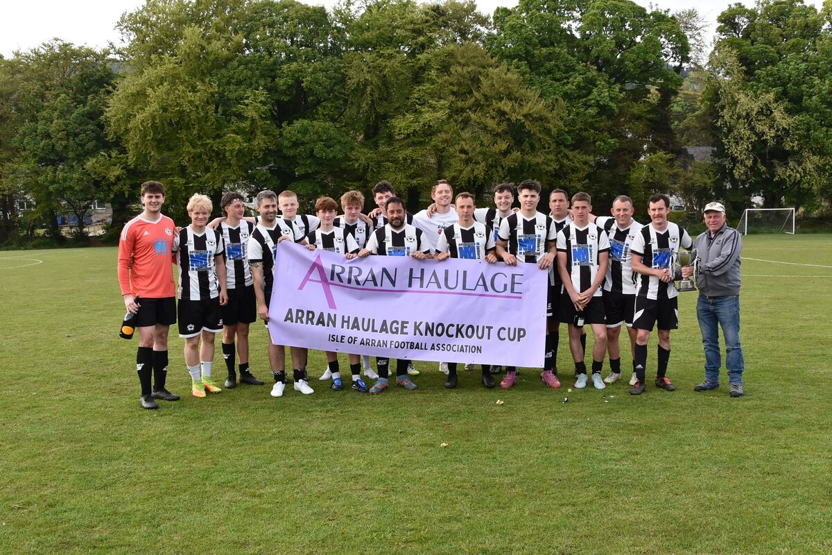 Donald 'Stud' Mckinnie presents Lamlash captain Sean Higgins with the Arran Haulage Cup.