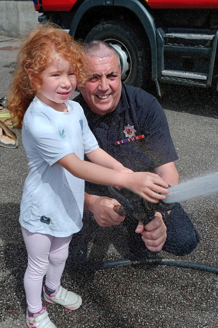 Natalie Galloway, aged 7, being shown the hose in action by firefighter Douglas Stewart. Photograph: Rita Campbell