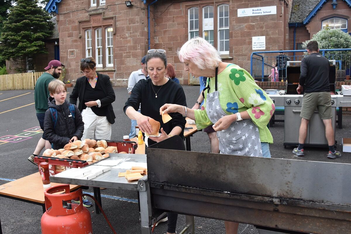 Volunteers man the barbecue stall that sold burgers and hot dogs. Volunteers man the barbecue stall that sold burgers and hot dogs.