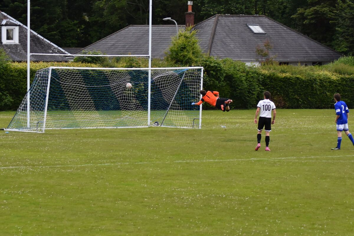 The Brodick keeper launches himself in the air to unsuccessfully try and prevent a goal from Sean Higgins.