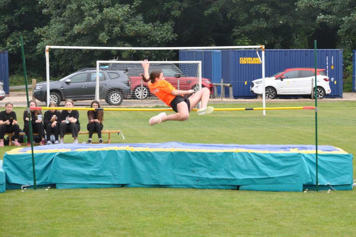 A high jumper successfully clears the bar in the girls high jump final.