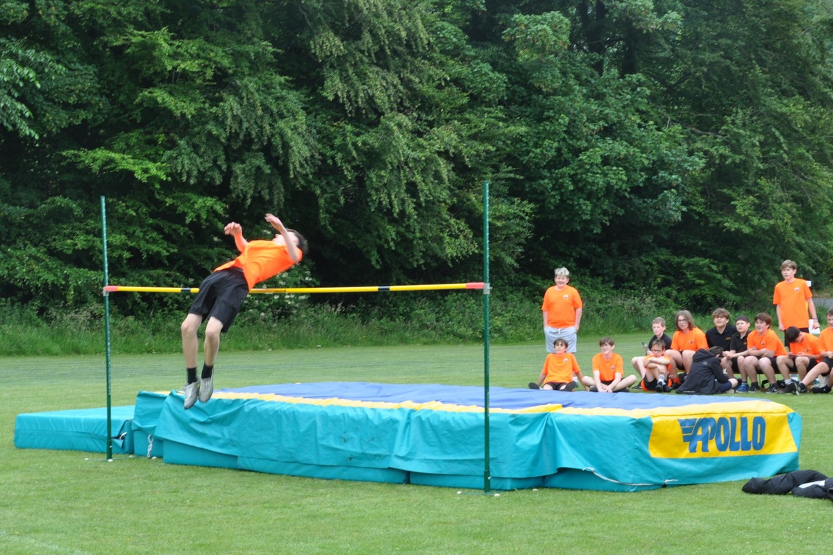 A competitor lifts himself cleanly over the bar in the final round of the high jump.
