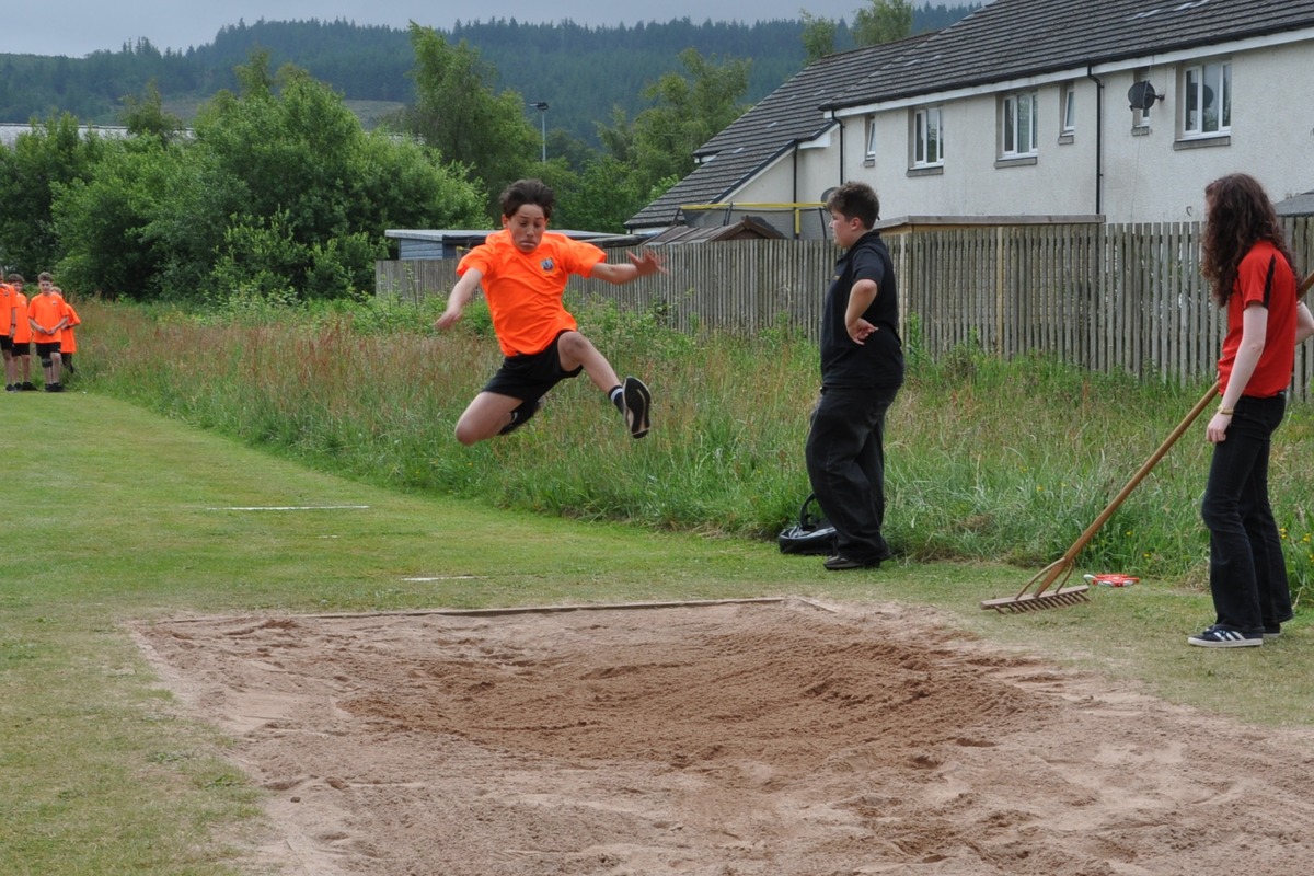Flying through the air in the junior boys long jump final.
