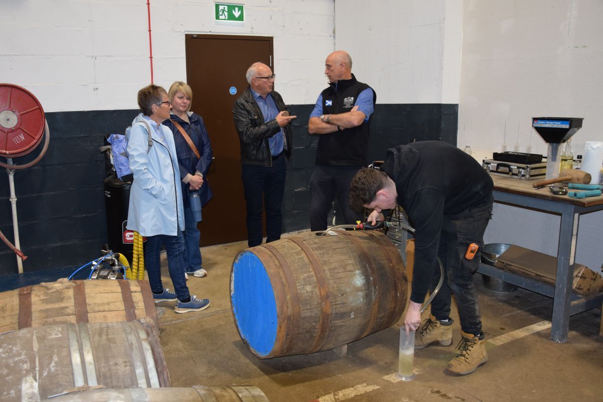 Warehouse operative Jayson McCallum demonstrates the regauging process to visitors, while managing director Fergus Wallace explains the operation.