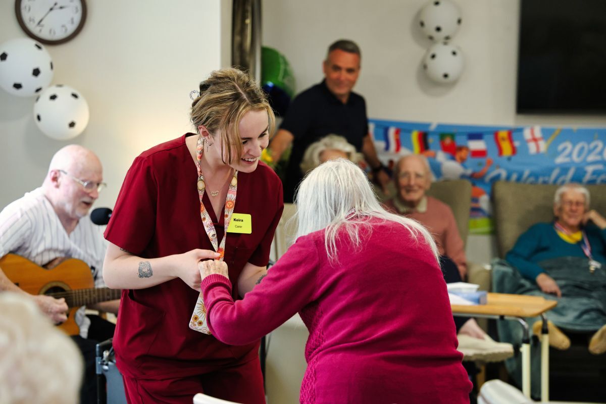 Staff member Keira Gillies dances with resident Anna Viola. 