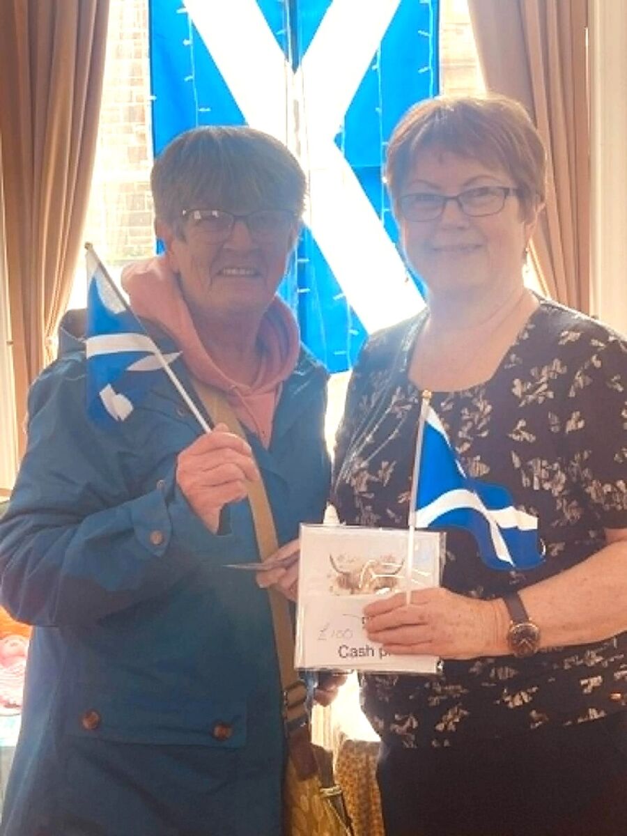 Nimble Fingers crafter Sandra Sloey, right, presents the £100 top raffle prize to delighted winner Meg Robertson.