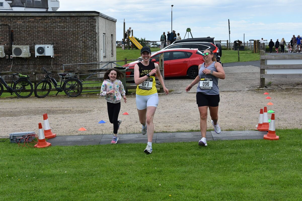 Jessica McGuire and Lucy Simpson cross the finish line.