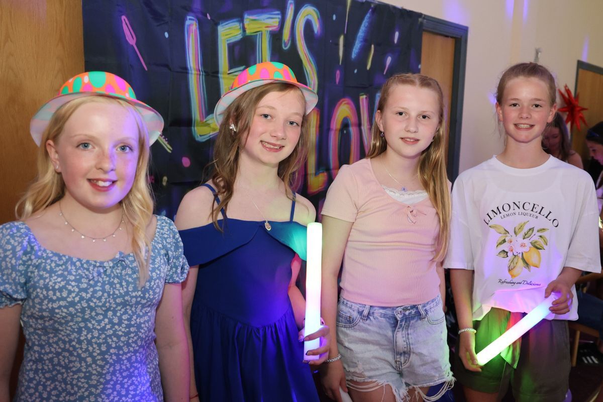 Friends pose with glow sticks at the disco.