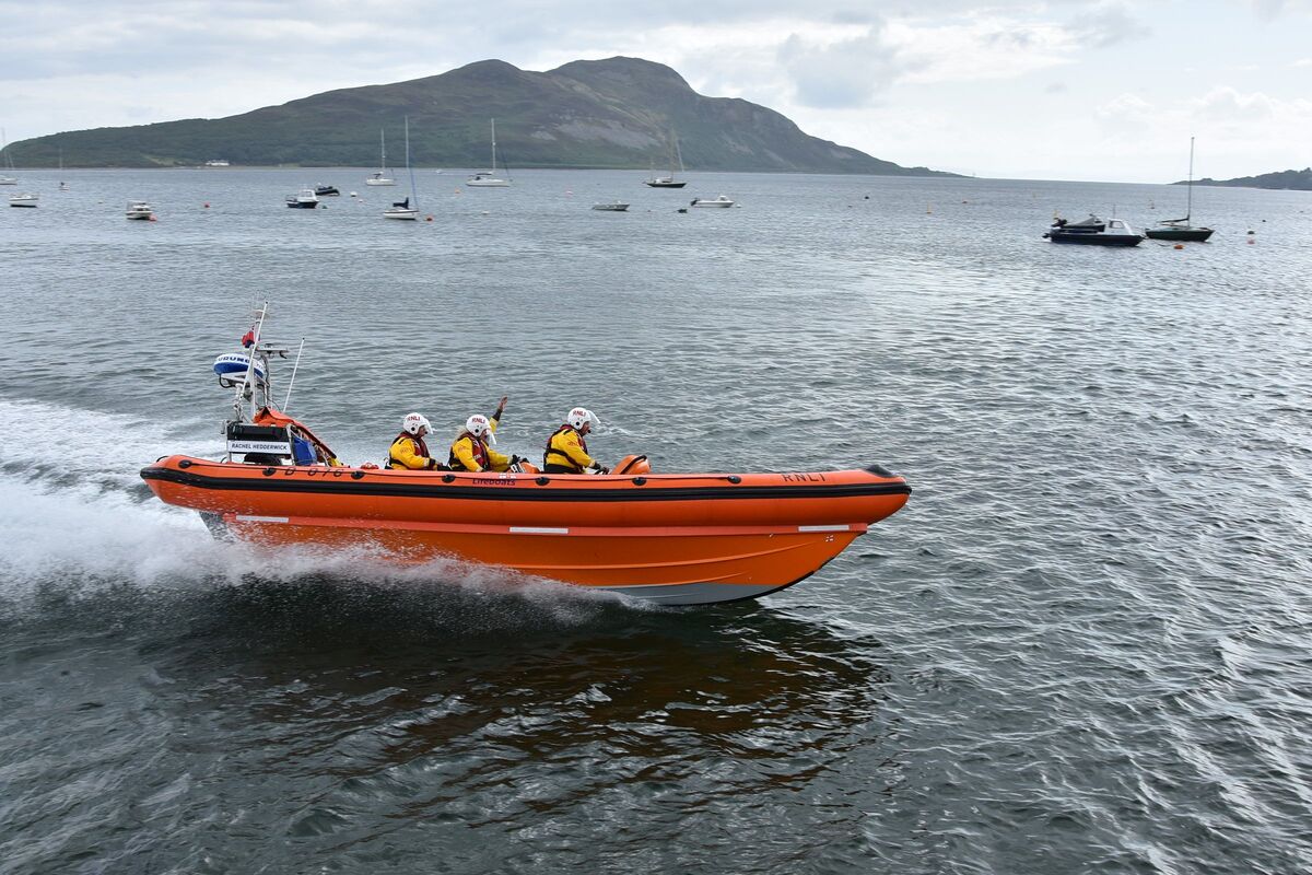 RNLI lifeboat Rachel Hedderwick speeds past the spectators on Lamlash pier during a demonstration of its speed and agility.