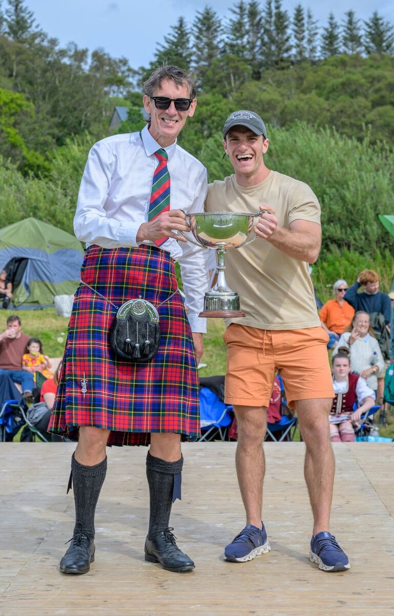 Chieftain Kenneth MacPherson presents Ramiro Polma with the Mowi trophy for first place in the Hill Race. Photograph: Phil Hughes.