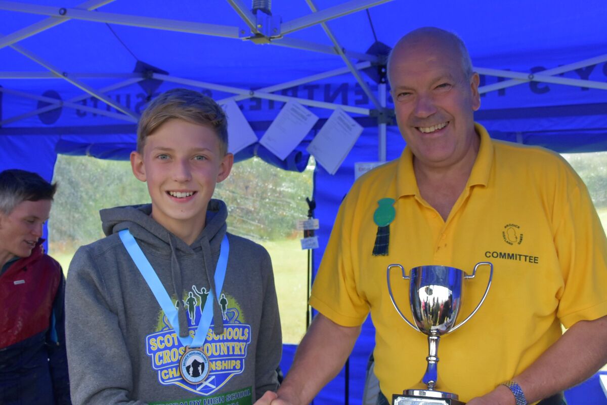 Brodick Highland Games chair, Donald McKelvie presents Fraser Edgar with the Stewart Dickie Trophy for his performance in the 100 metres race for under 12s. Brodick Highland Games chair, Donald McKelvie presents Fraser Edgar with the Stewart Dickie Trophy for his performance in the 100 metres race for under 12s.