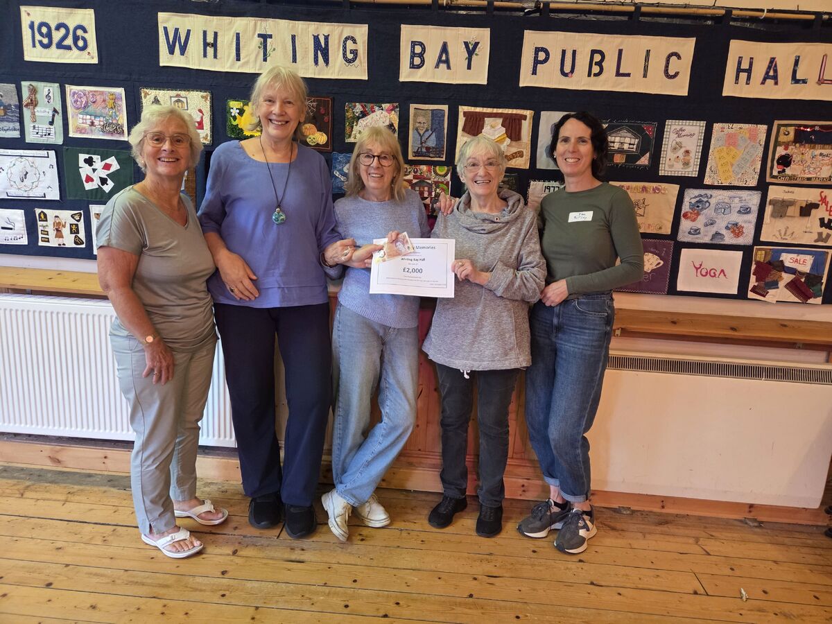 Joyce MacGregor and Susan McNicol of Whiting Bay Memories with Sandy and Zoe McGovern and Kirsty Lewis of Whiting Bay Hall Committee. Photograph: WBM.