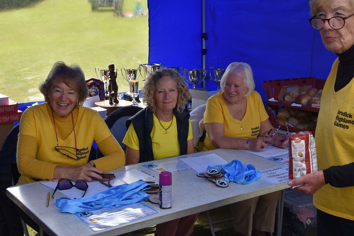 Record keepers and logistical support volunteers in the secretary’s tent at the Brodick Highland Games. Record keepers and logistical support volunteers in the secretary’s tent at the Brodick Highland Games.