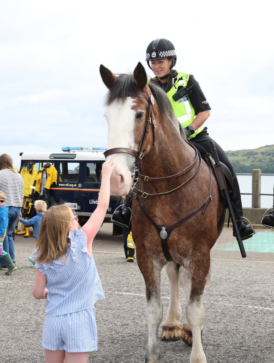 Naomi White says hello to the mounted police horses. Photograph: Kenny Craig.