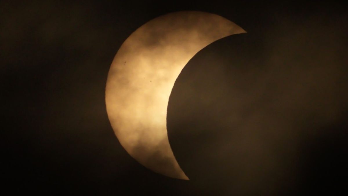 A break in the cloud reveals the Moon passing across the face of the Sun during the partial solar eclipse over Kintyre. Photograph: Greg Grogan.