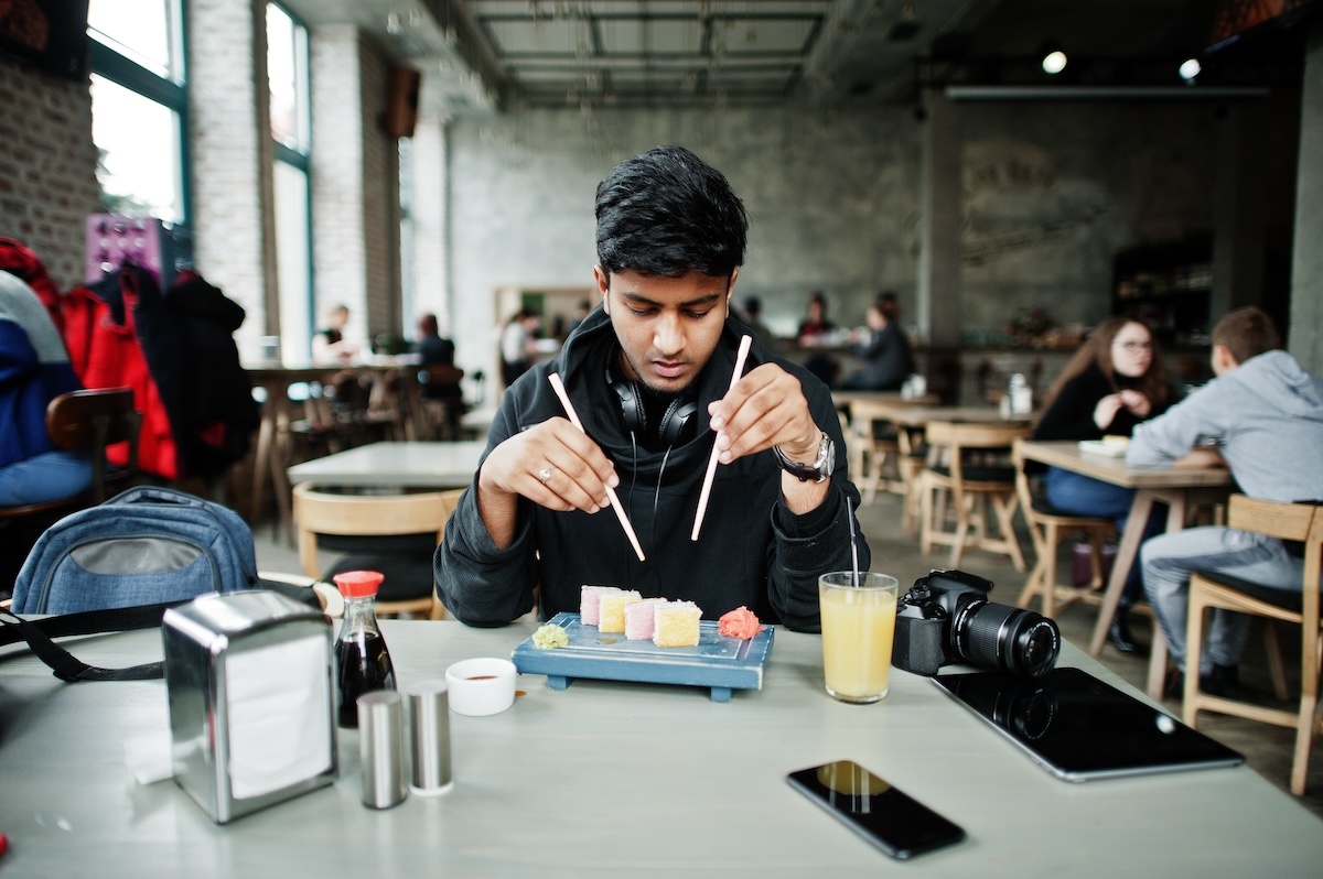 indian man eating sushi AdobeStock 262890452