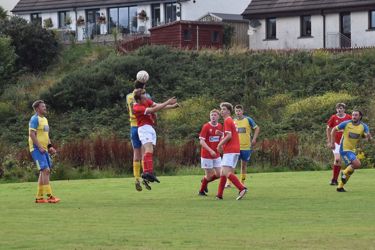 James Currie playing for Shiskine, and Ryan Armstrong leap into the air to intercept an incoming ball. James Currie playing for Shiskine, and Ryan Armstrong leap into the air to intercept an incoming ball.