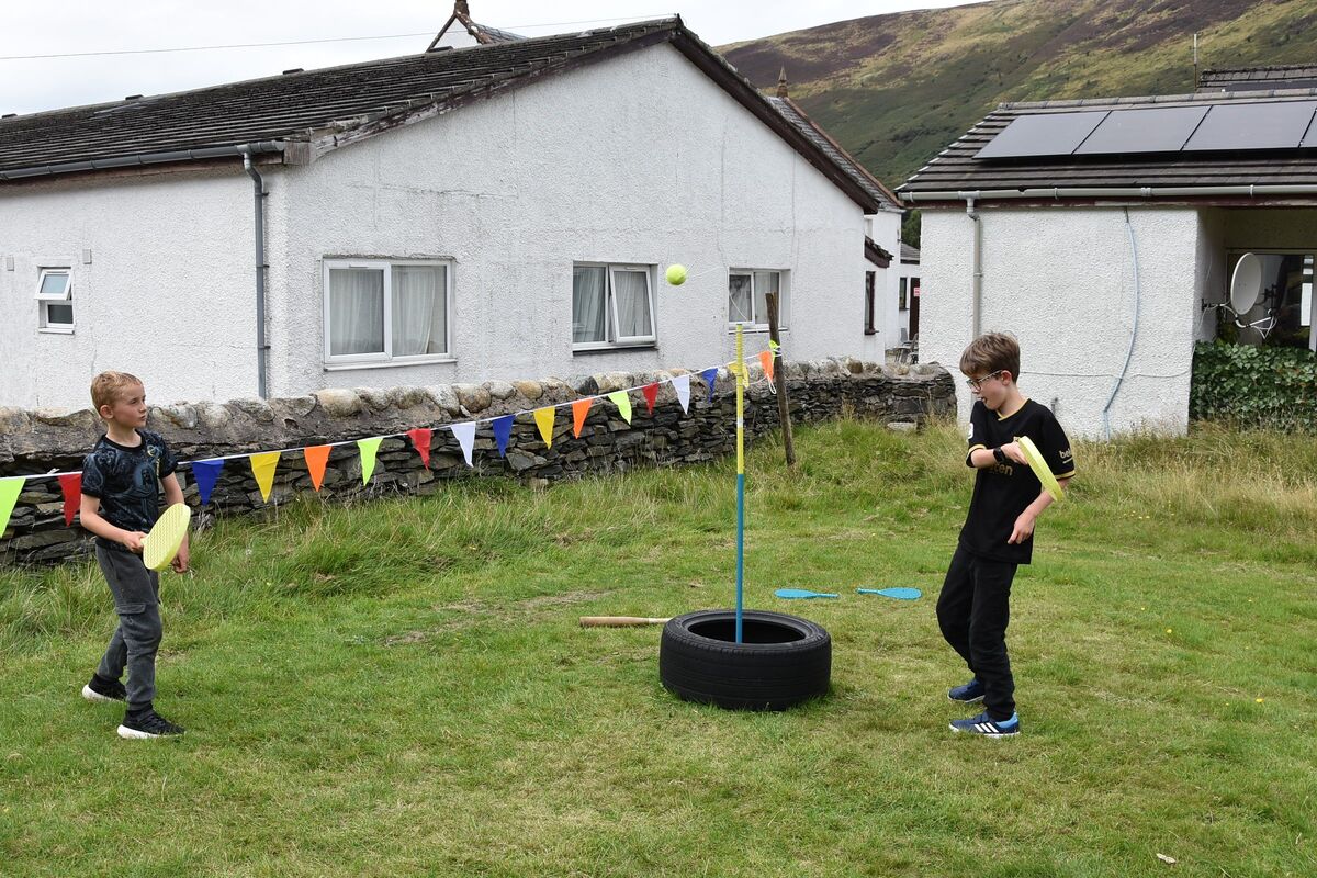 Two young boys try swing ball for the first time.